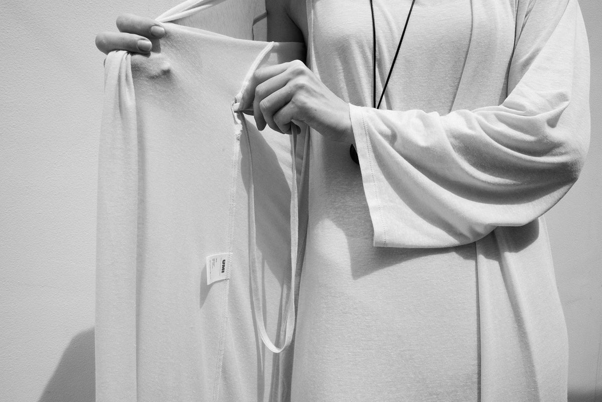 Hands holding a softly draped knitted garment
